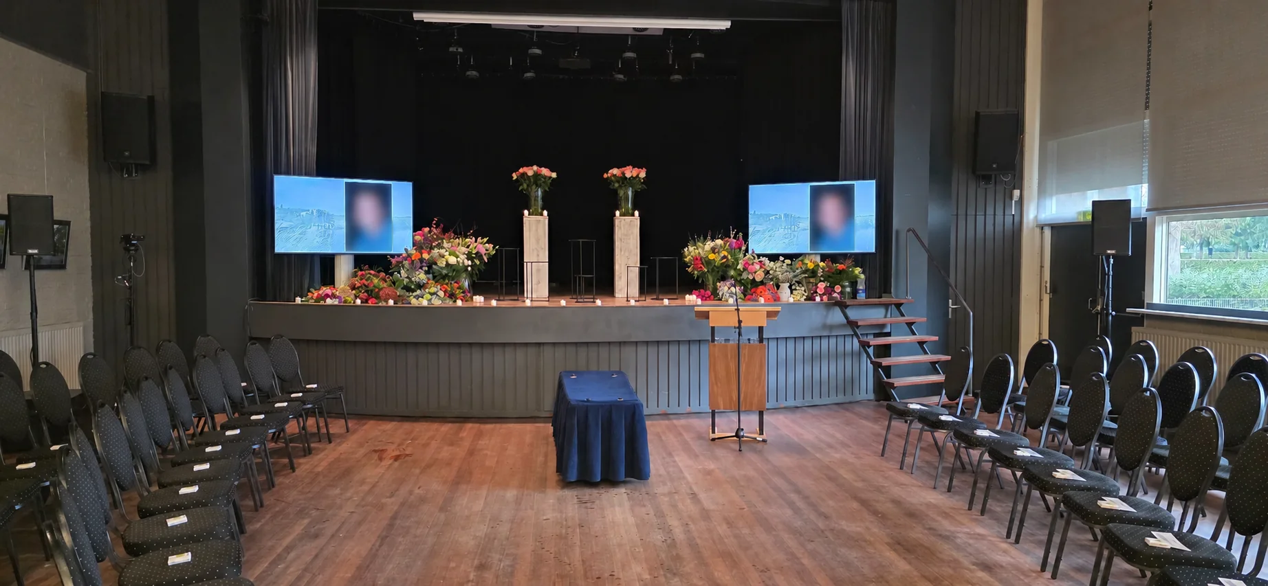 Ceremonieruimte met twee grote schermen voor beeldpresentaties